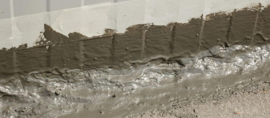 Close up of the first layer of an waterproofing ms polymer sealant freshly applied on an outside wall-floor connection
